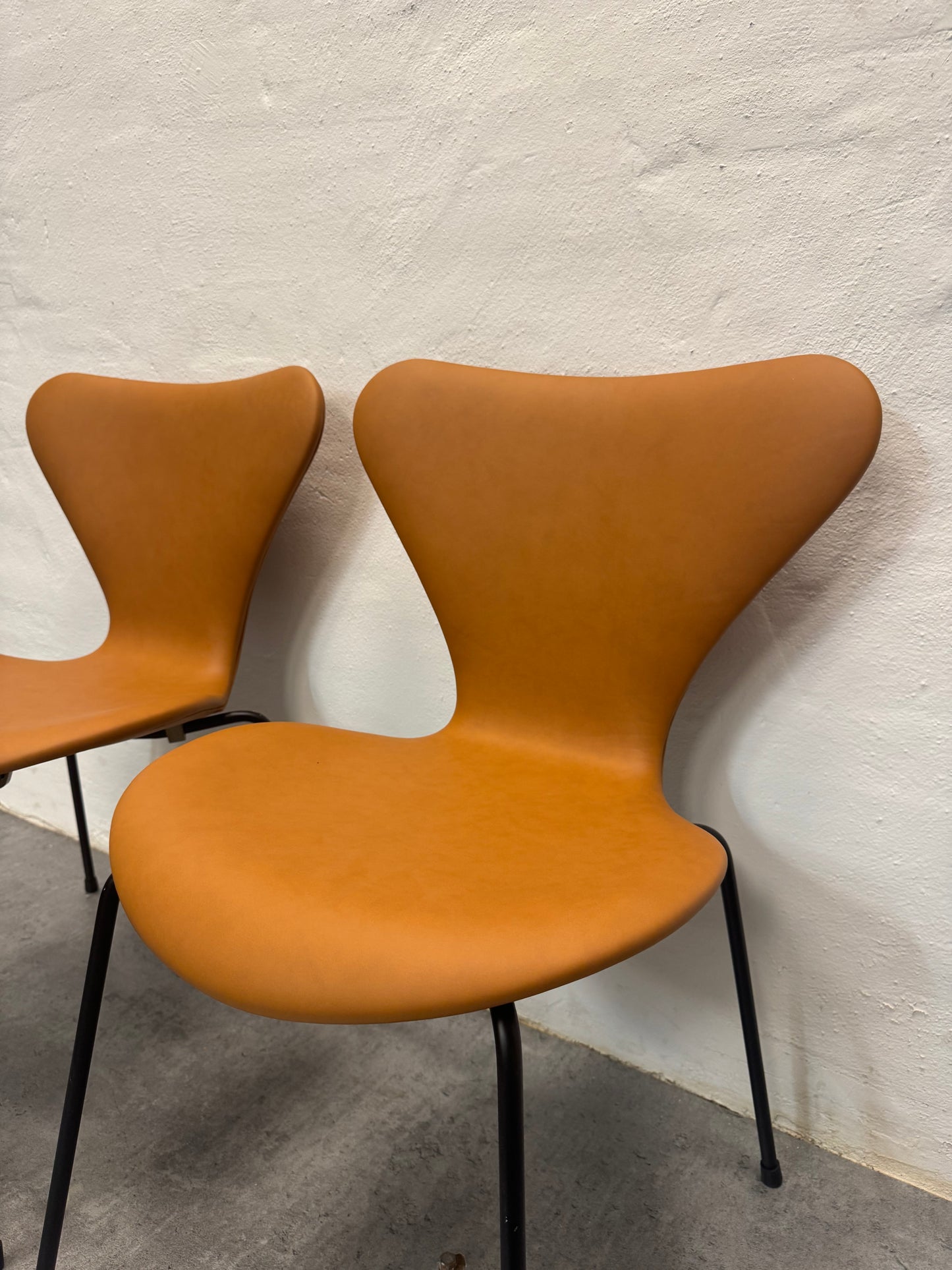 Nypolstrede Arne Jacobsen ‘3107’ Syverstol i cognac læder.