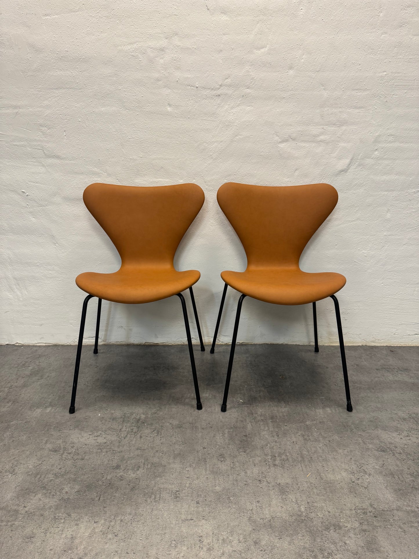 Nypolstrede Arne Jacobsen ‘3107’ Syverstol i cognac læder.