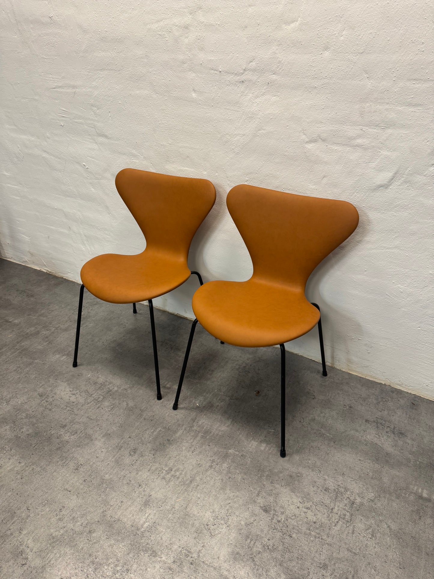 Nypolstrede Arne Jacobsen ‘3107’ Syverstol i cognac læder.